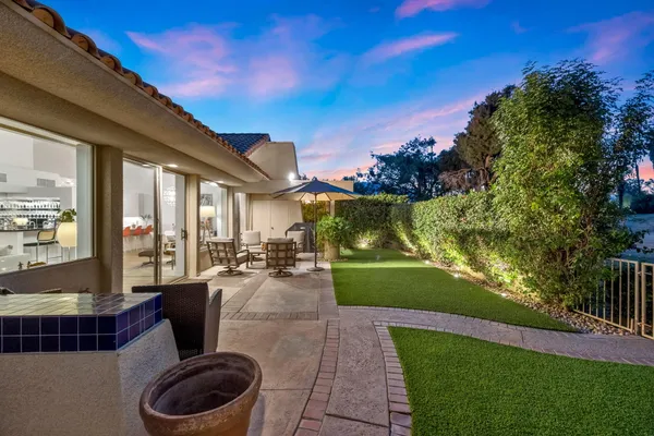 a view of a house with a yard and potted plants