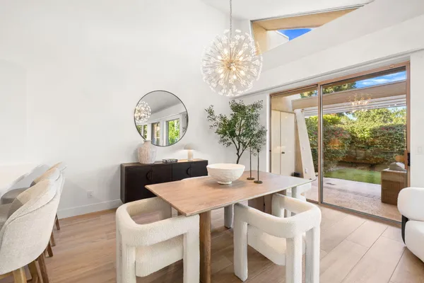 a view of a dining room with furniture a chandelier and wooden floor