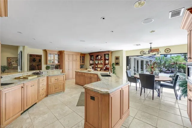 a large white kitchen with a large window and white cabinets