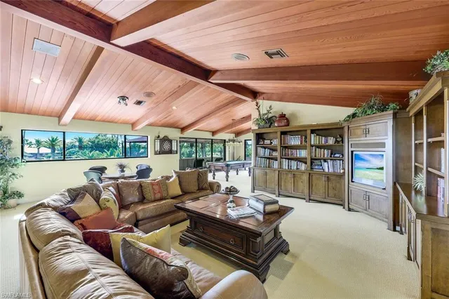a living room with furniture a bookshelf and a large window