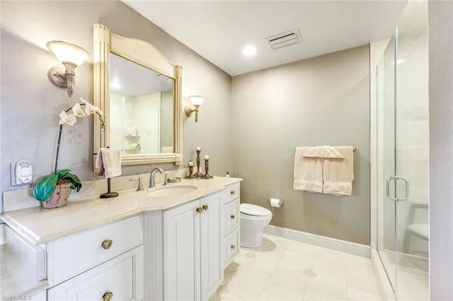 a bathroom with a double vanity sink mirror and toilet