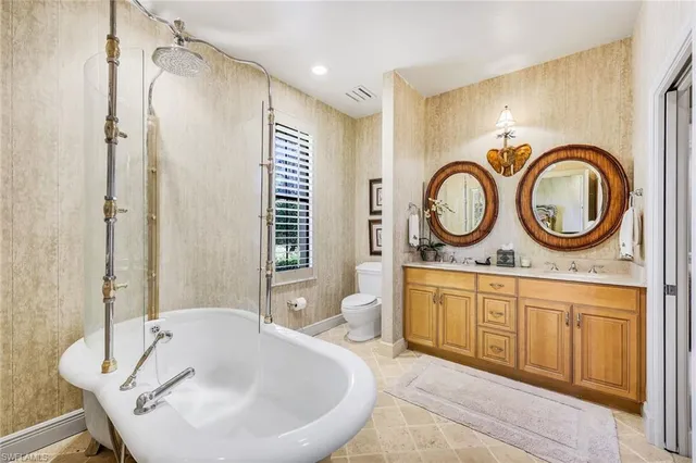 a bathroom with a tub a mirror and a sink