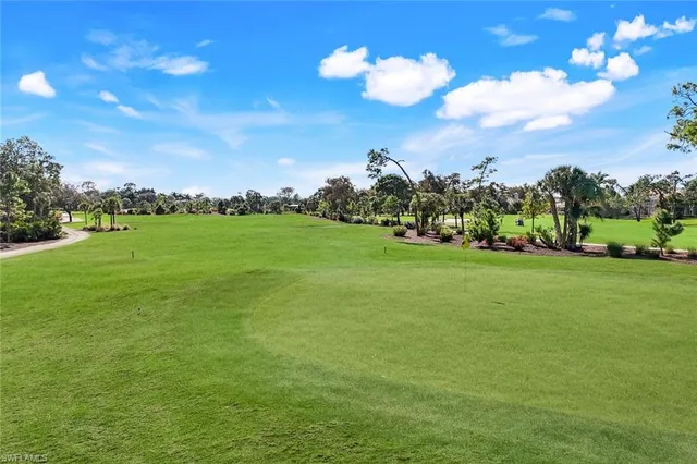a view of a golf course with an outdoor space and seating