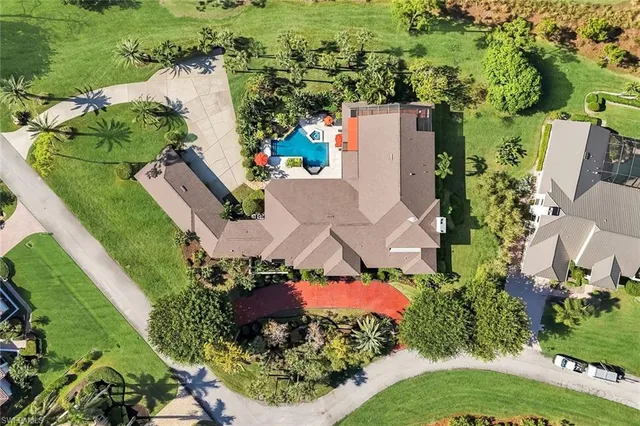 an aerial view of a house with a yard and lake view