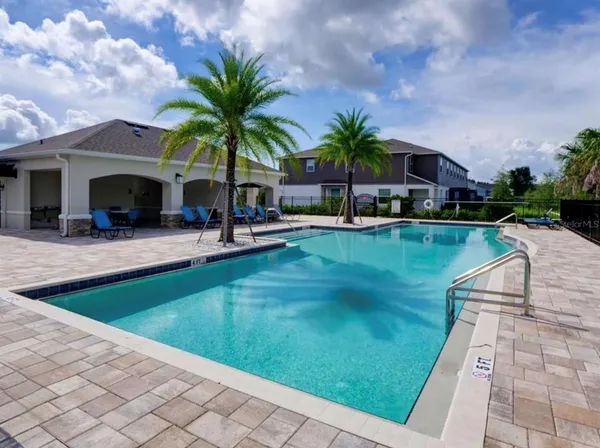 a swimming pool with outdoor seating and yard
