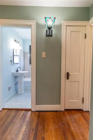 a view of a livingroom with wooden floor and a bathroom