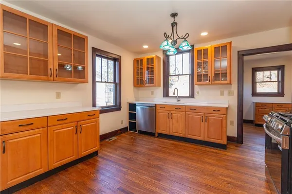 a large kitchen with granite countertop a large counter top space a sink stainless steel appliances and cabinets