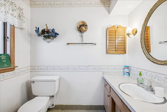 a bathroom with a sink vanity mirror and toilet