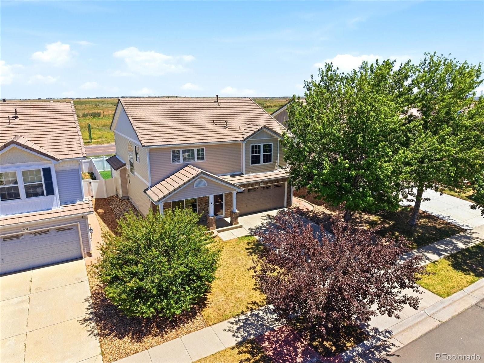 5444 Perth Court Denver, CO 80249 - Photo 2 of 46 a aerial view of a house with a yard and large tree