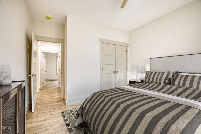 a bedroom with a bed and a flat tv screen on dresser