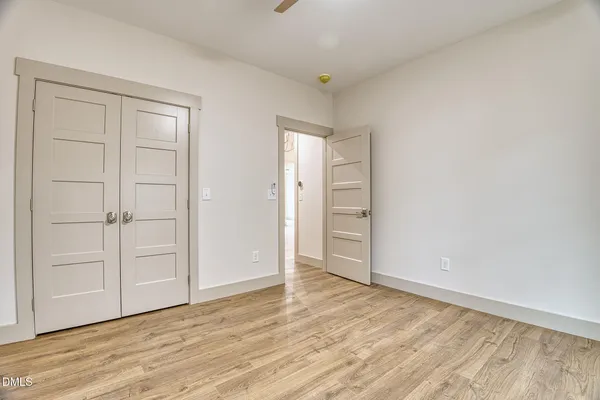 a bedroom with a bed and a flat tv screen on dresser