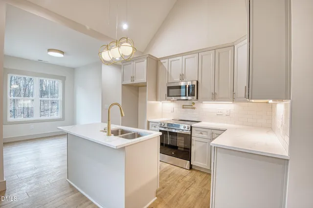 a kitchen with stainless steel appliances granite countertop a sink stove and cabinets