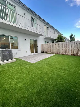 a view of a house with a yard and wooden fence