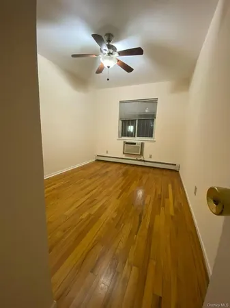 a view of an empty room with a chandelier fan and a window
