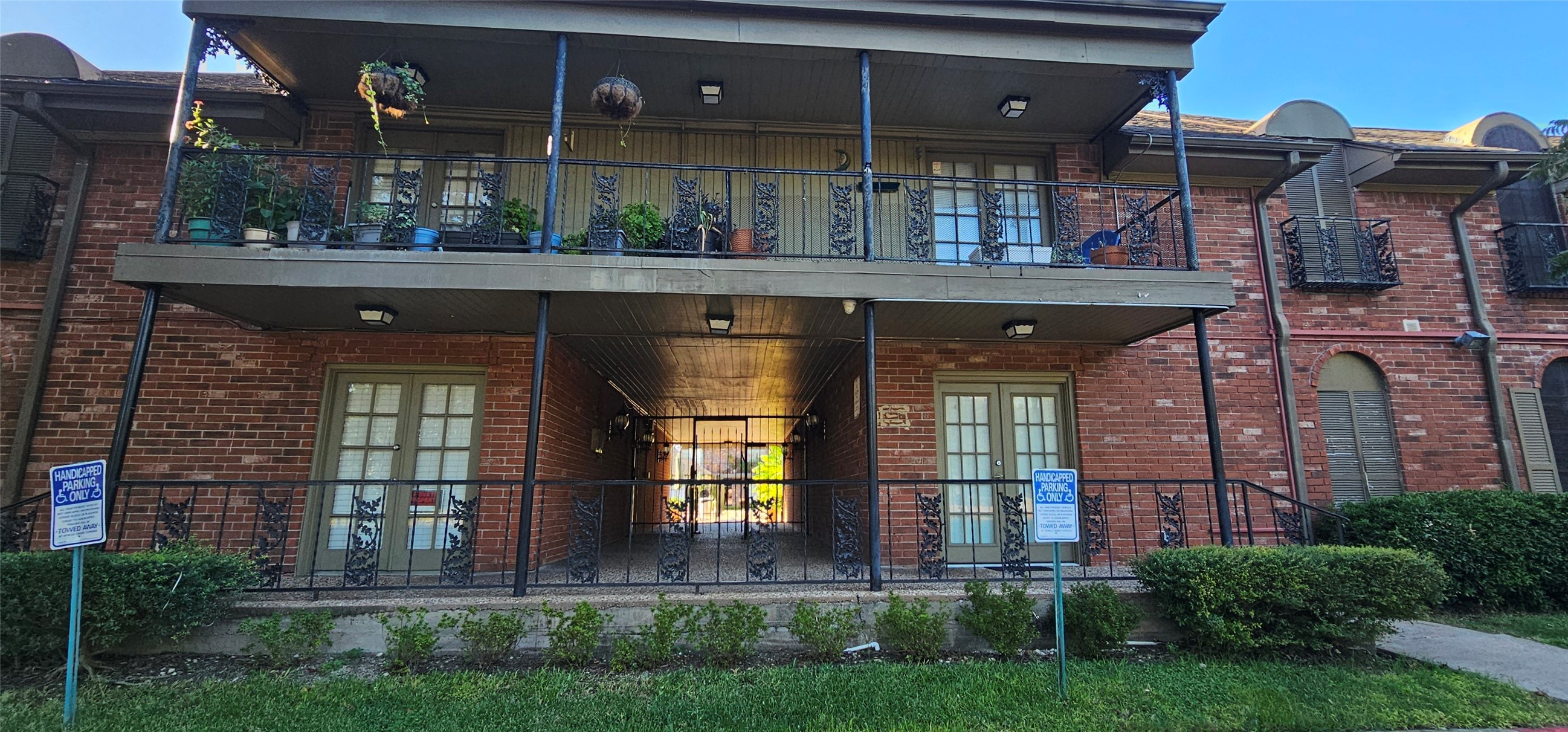 11550 Chimney Rock Road, Unit 205 Houston, TX 77035 - Photo 1 of 27 Classic two-story brick exterior with decorative wrought-iron railings and lush greenery, offering a charming first impression of the community.