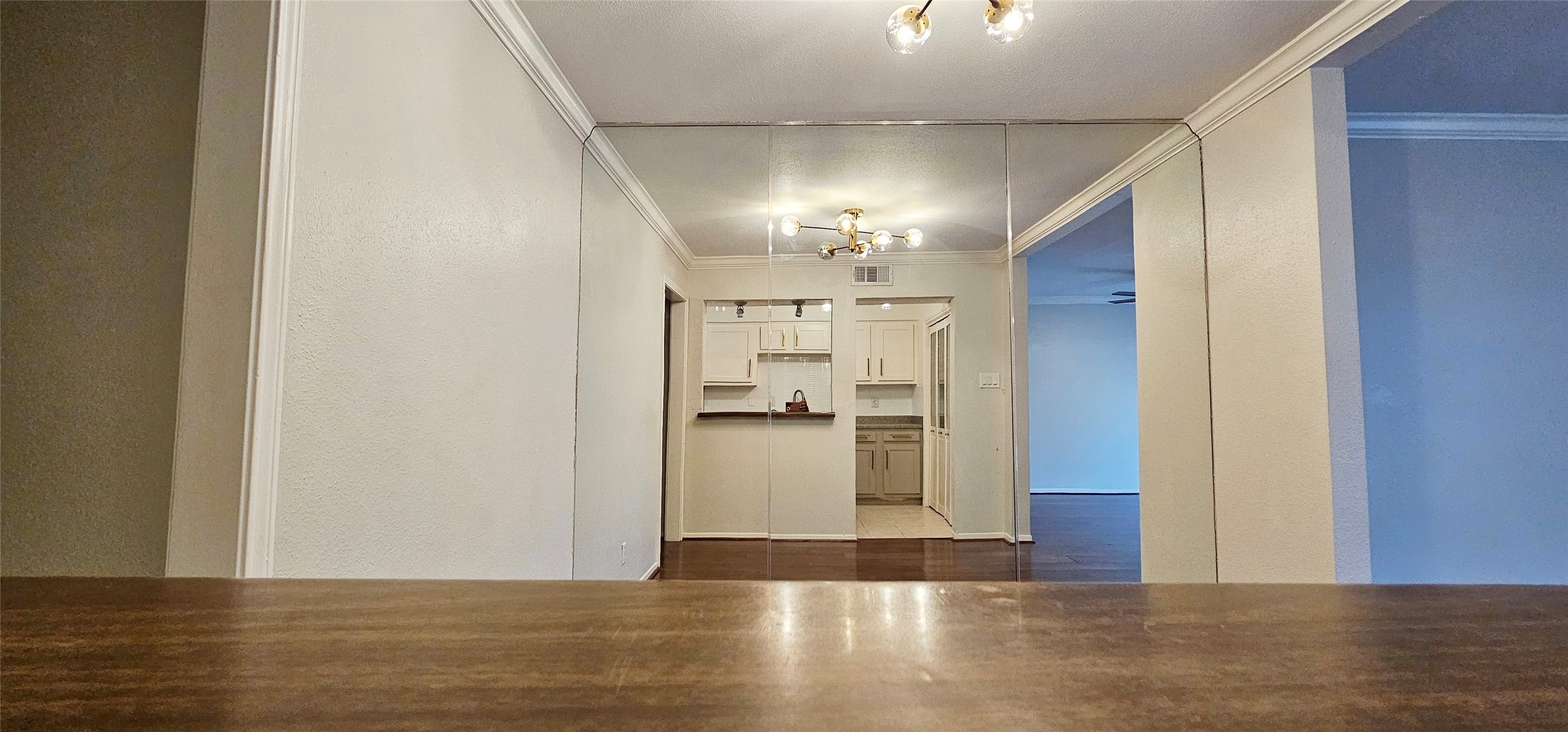 11550 Chimney Rock Road, Unit 205 Houston, TX 77035 - Photo 11 of 27 a view of a hallway with wooden floor a kitchen space with a refrigerator and a window