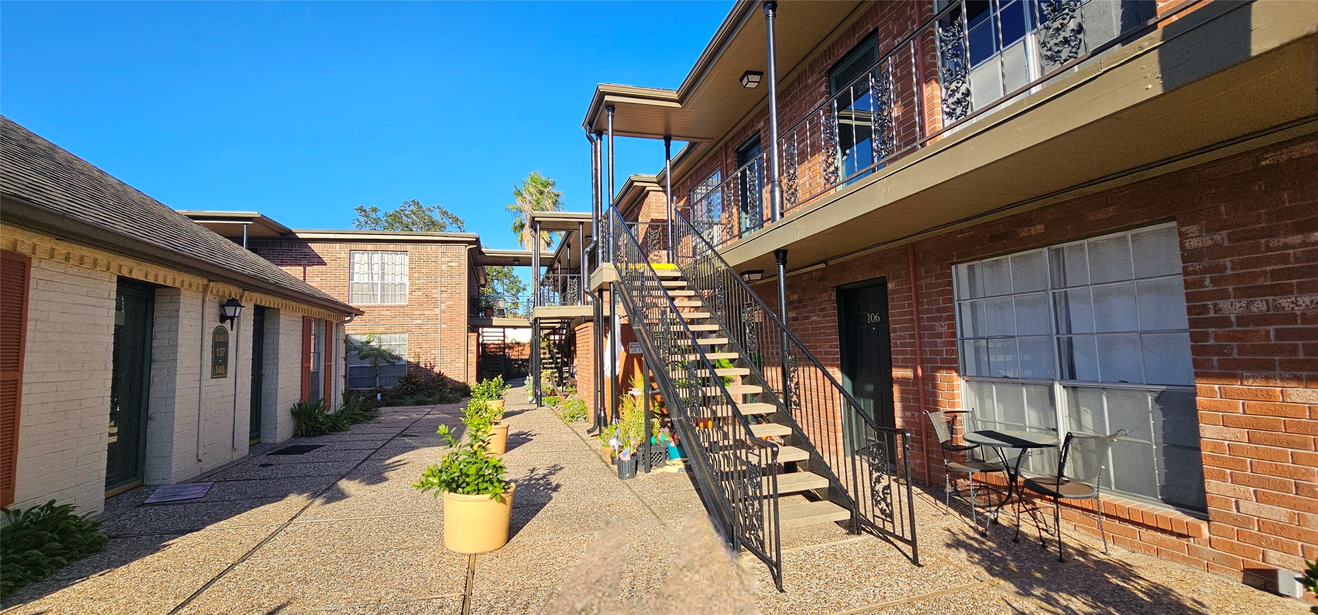 11550 Chimney Rock Road, Unit 205 Houston, TX 77035 - Photo 20 of 27 Front exterior view of Westbury Square Condos with mature trees, manicured landscaping, and traditional architecture.
