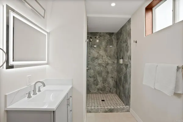 a bathroom with a shower sink and mirror