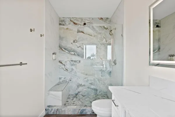 a white toilet sitting next to a bathroom