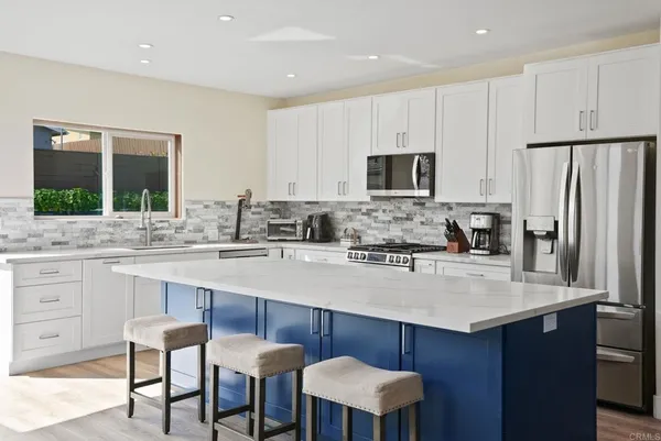 a kitchen with stainless steel appliances a sink stove and refrigerator