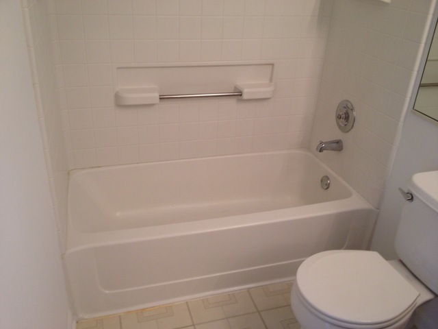 9471 Harrison Street Des Plaines, IL 60016 - Photo 4 of 9 a white toilet sitting next to a bath tub