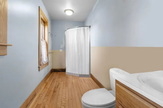 a bathroom with a granite countertop toilet sink and mirror