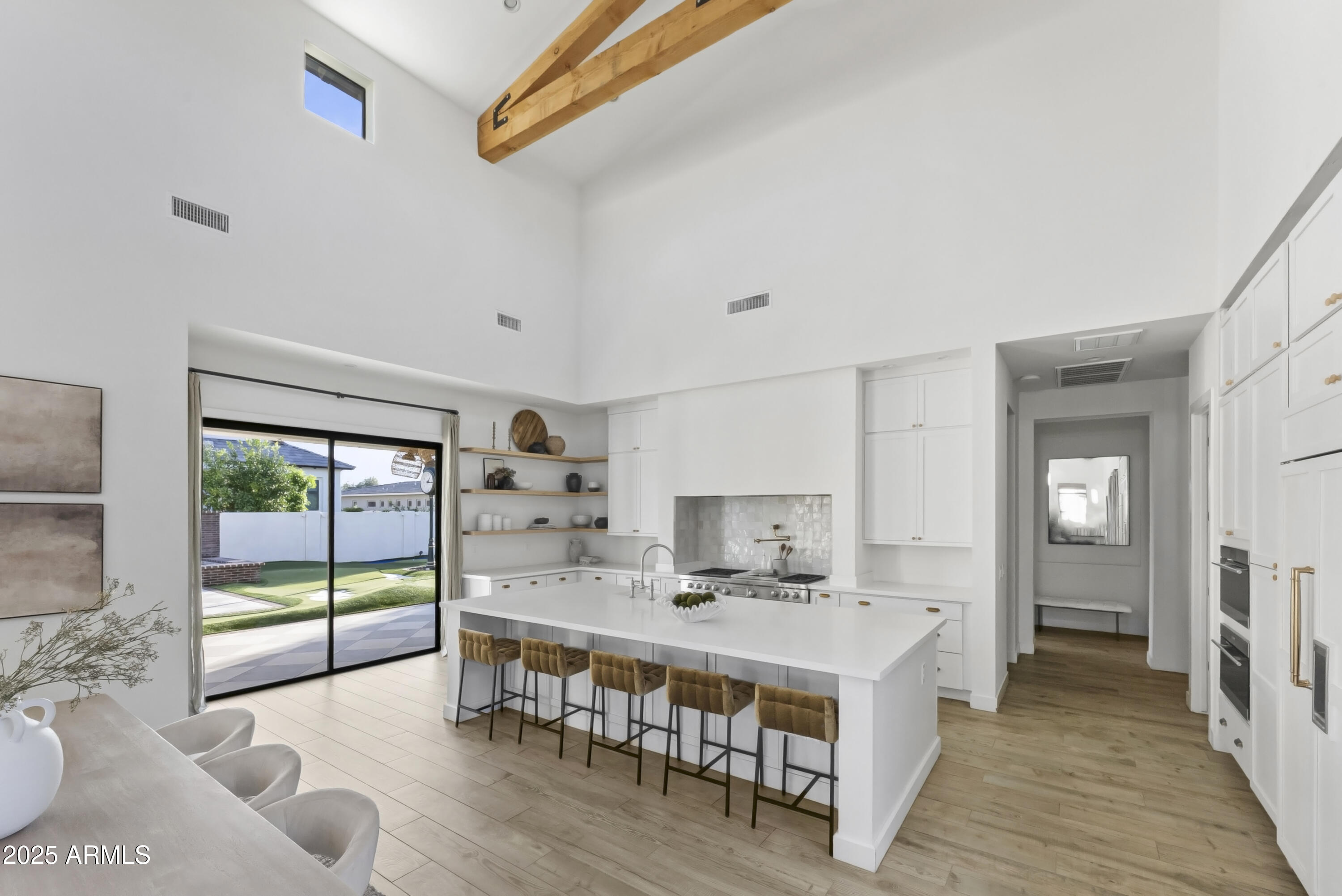2753 East Hummingbird Way Gilbert, AZ 85297 - Photo 16 of 44 a open kitchen with stainless steel appliances a stove a sink dishwasher and white cabinets with wooden floor