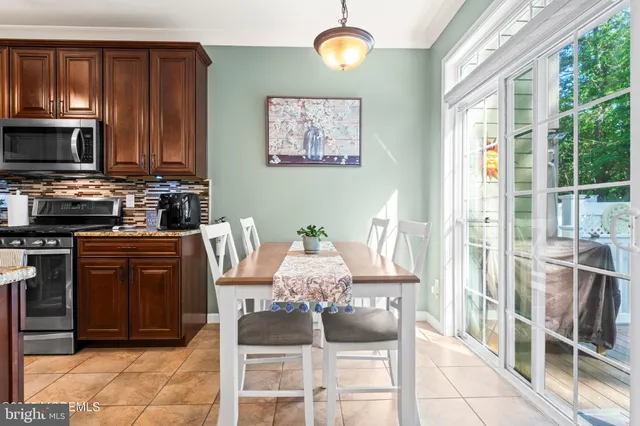 a dining room with wooden floor a chandelier a wooden table and chairs