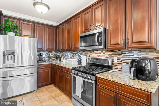a kitchen with granite countertop a refrigerator stove top oven and sink