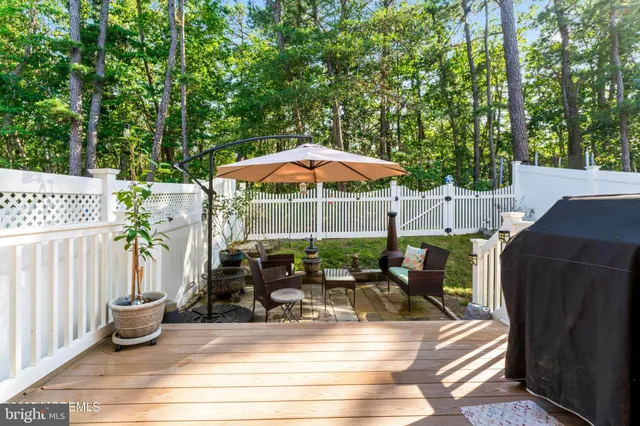 a view of a patio with table and chairs under an umbrella with wooden fence