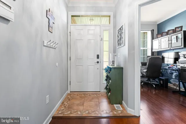 a view of a hallway with wooden floor and a living room