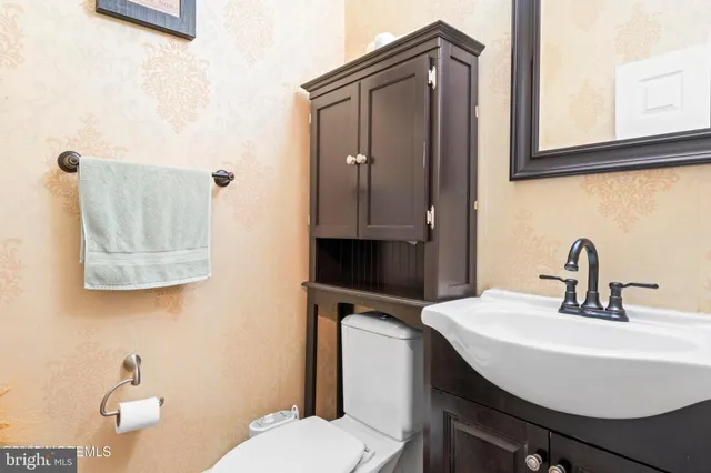 a bathroom with a sink a toilet and mirror