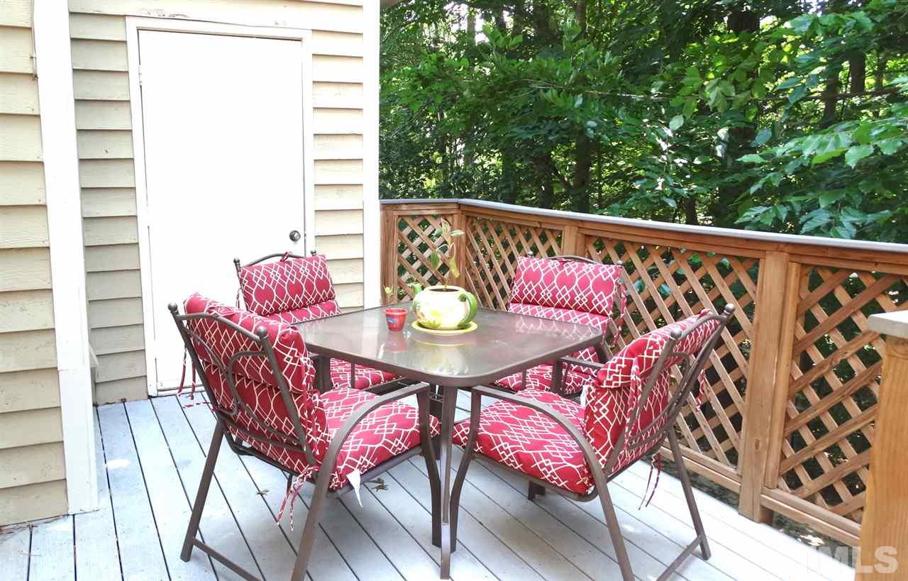 A 2-level Trex deck with lush greenery behind for outdoor dining and entertainment