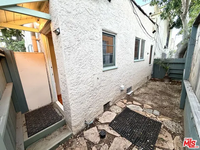 a backyard of a house with wooden floor and outdoor seating
