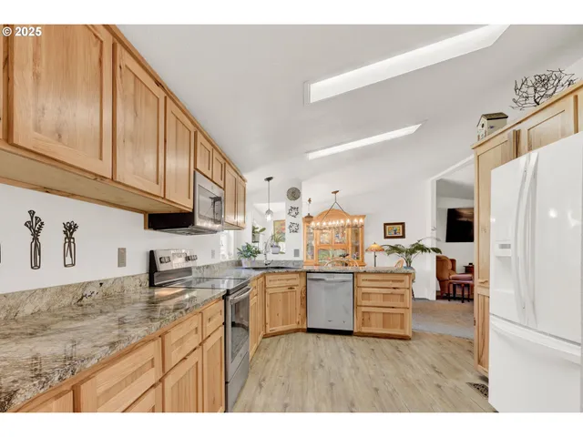 a kitchen with stainless steel appliances granite countertop a refrigerator and microwave