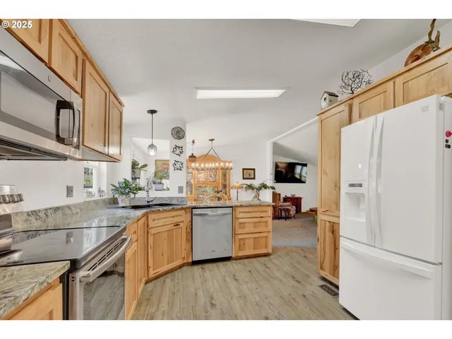 a kitchen with stainless steel appliances granite countertop a refrigerator and a stove top oven