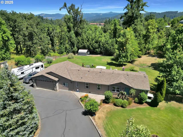 an aerial view of a house with yard and green space