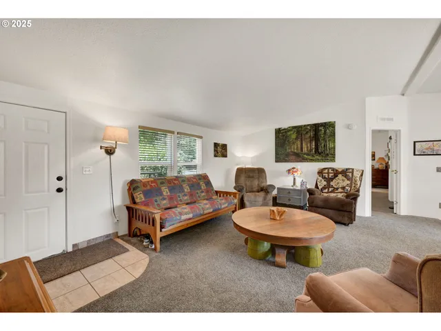 a living room with furniture a rug and a window