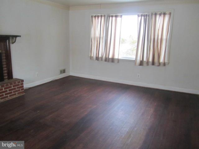 2432 Holly Neck Road Baltimore, MD 21221 - Photo 3 of 27 an empty room with wooden floor and windows
