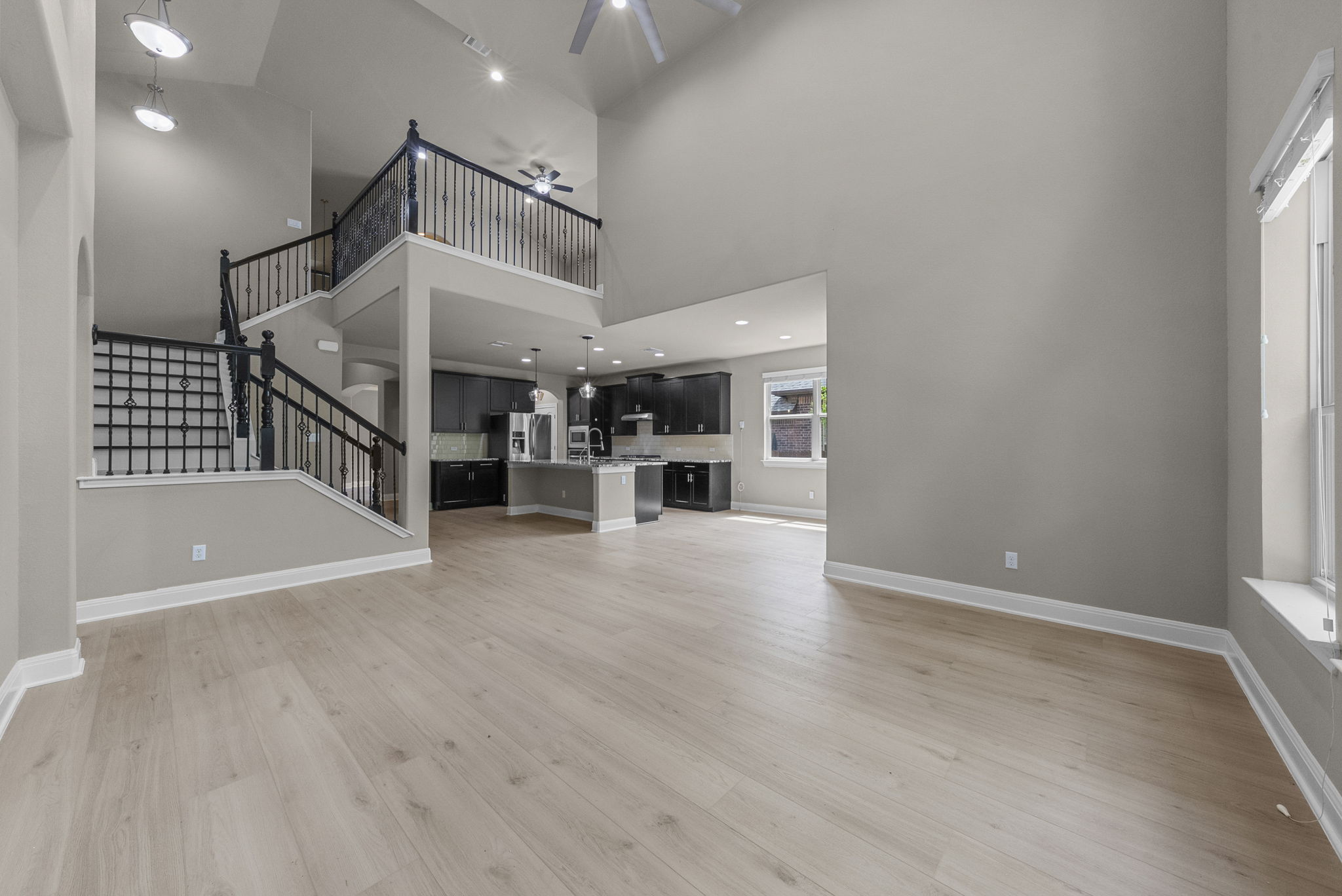 4401 Trinity Woods Street Leander, TX 78641 - Photo 37 of 37 An airy great room combines with a kitchen and features light wood flooring, an open floorplan, and high ceilings.