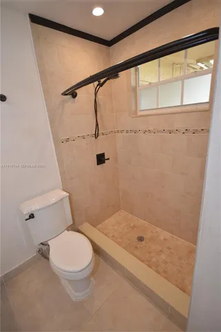 a bathroom with a granite countertop sink a toilet and shower