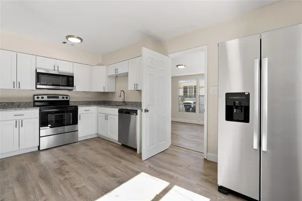 a kitchen with white cabinets and stainless steel appliances
