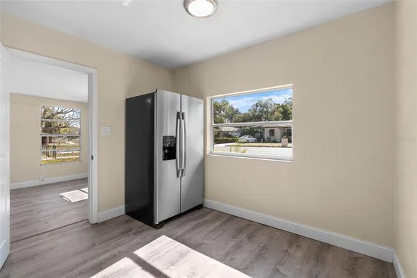 a view of an empty room with window and wooden floor