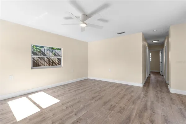 an empty room with wooden floor and windows