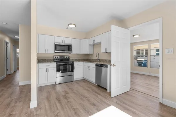 a kitchen with granite countertop a refrigerator and a stove top oven