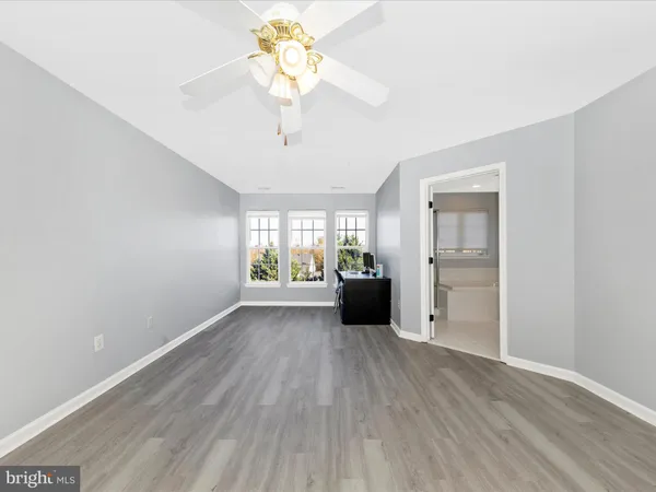 a view of an empty room with a window and a kitchen