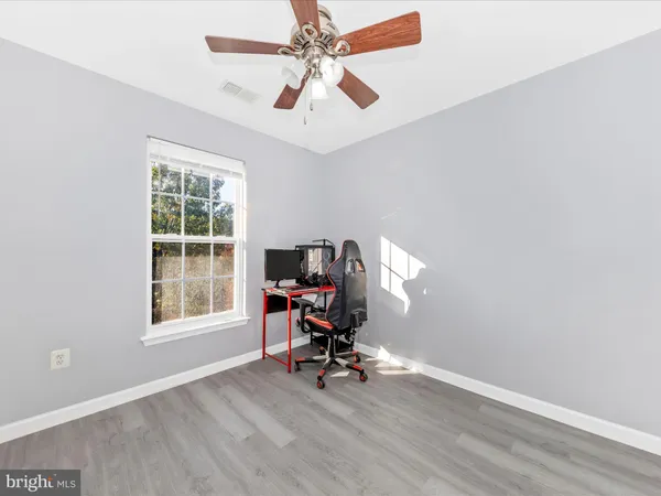 a view of a workspace with furniture and a window