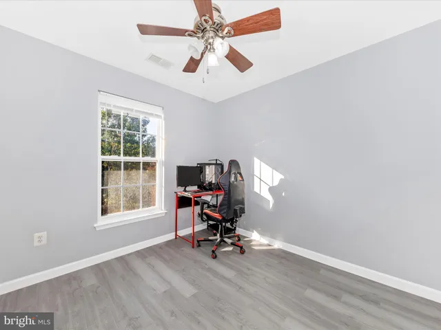 a view of a workspace with furniture and a window