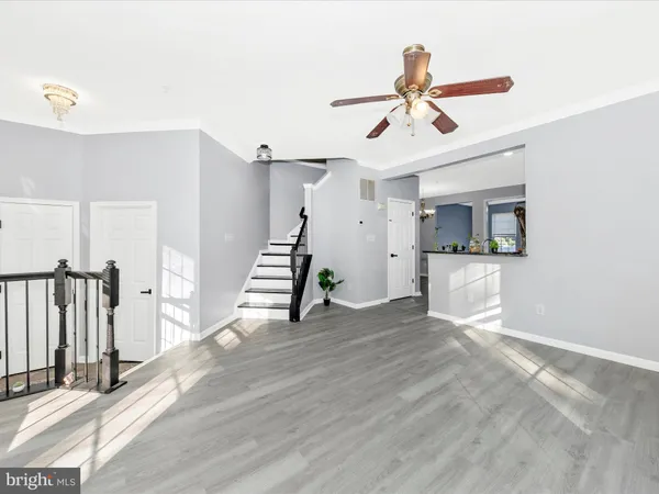 a view of a livingroom with wooden floor and a ceiling fan