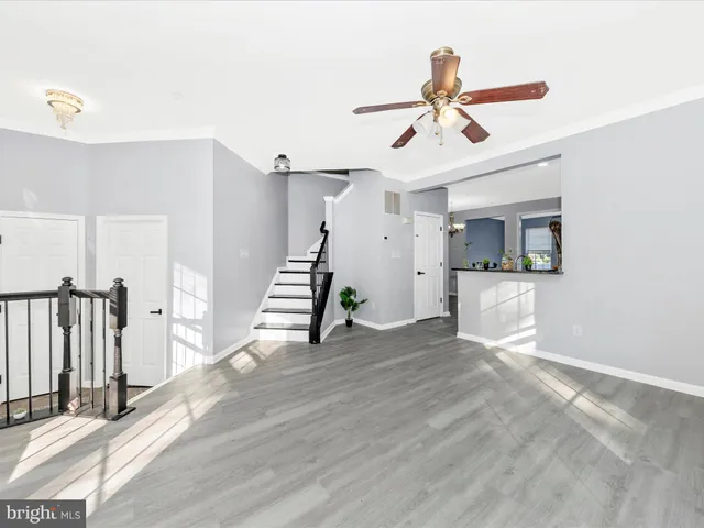 a view of a livingroom with wooden floor and a ceiling fan